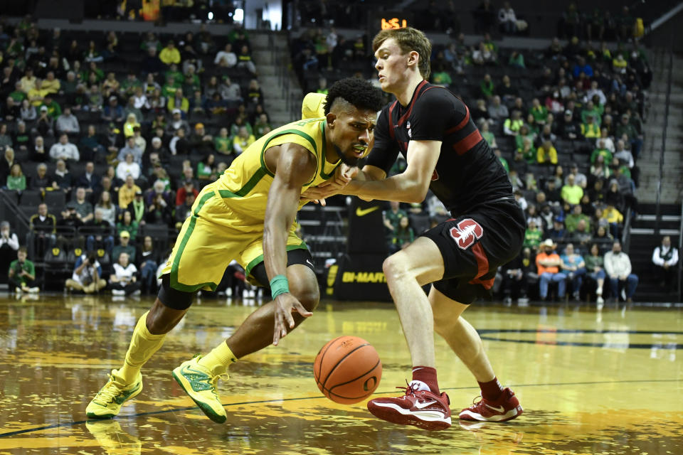 Oregon forward Quincy Guerrier, left, is fouled by Stanford forward Max Murrell, right, as he drives to the basket during the first half of an NCAA college basketball game Saturday, March 4, 2023, in Eugene, Ore. (AP Photo/Andy Nelson)