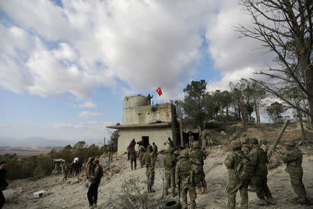 FILE PHOTO - Turkish forces wave a flag on Mount Barsaya, northeast of Afrin, Syria January 28, 2018. REUTERS/ Khalil Ashawi