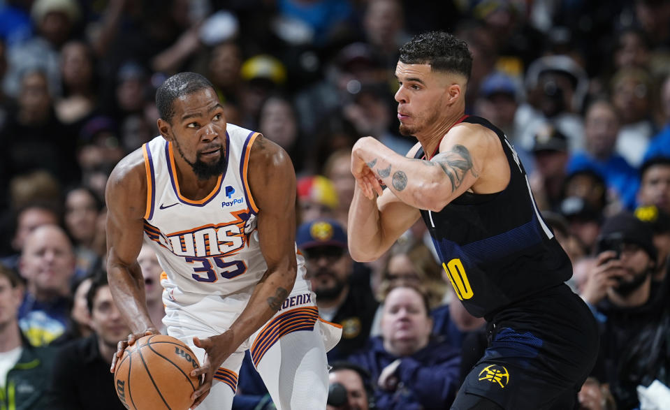 Phoenix Suns forward Kevin Durant, left, is defended by Denver Nuggets forward Michael Porter Jr. during the second half of an NBA basketball game Wednesday, March 27, 2024, in Denver. (AP Photo/David Zalubowski)