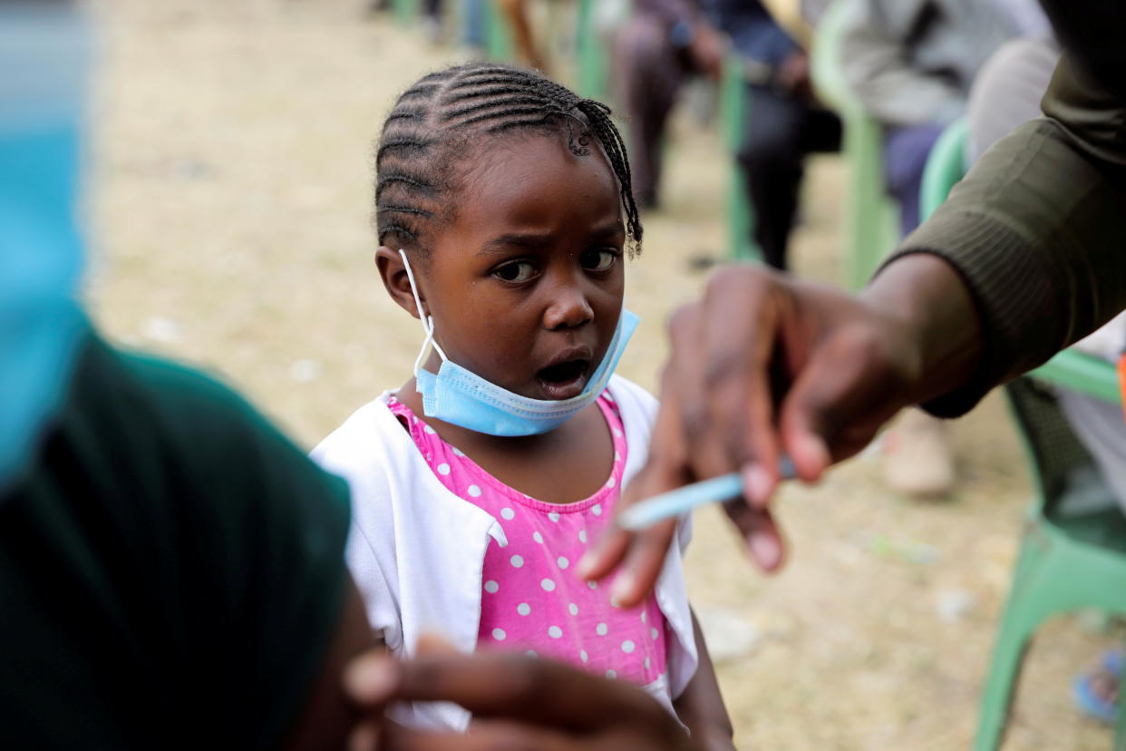 A girl reacts as her father receives an AstraZeneca/Oxford coronavirus disease (COVID-19) vaccine, donated to Kenya by the UK government, in Nairobi, Kenya, August 8, 2021. REUTERS/Baz Ratner     TPX IMAGES OF THE DAY