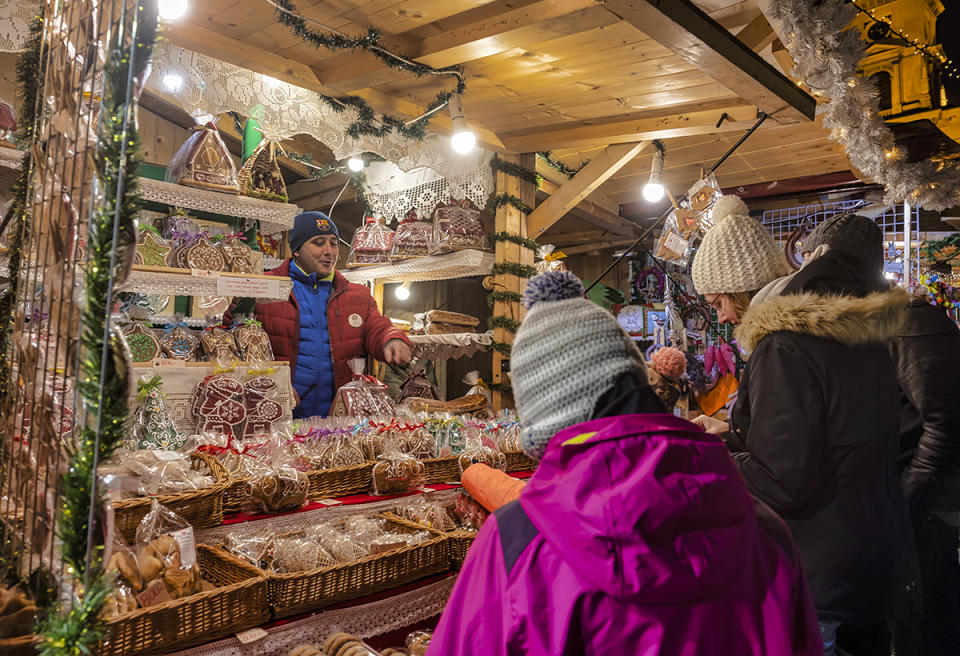 best christmas markets around the world, BUDAPEST, HUNGARY - DECEMBER 16: A stallkeeper offers gingerbread at the Christmas Market in front of the Szent Istv√°n Bazilika (St. Stephen's Basilica) on December 16, 2018 in Budapest, Hungary. The best-known Christmas Market of Budapest is organised from year to year in front of Szent Istv√°n Bazilika (St. Stephen's Basilica) at the Szent Istv√°n t√©r (St. Stephen square). (Photo by Laszlo Szirtesi/Getty Images)