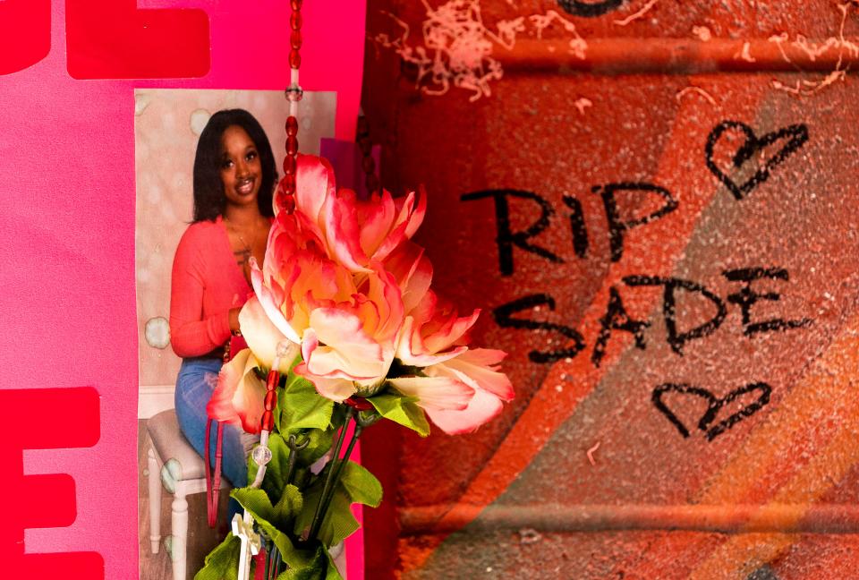 A photo of Sade Robinson is seen at a memorial April 19 at Pizza Shuttle, where friends and family, along with other community members, left various items, such as a poster, flowers and stuffed animals. Sade Robinson worked at Pizza Shuttle on Milwaukee's east side for three years.