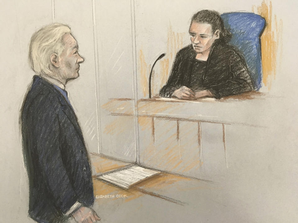 Courts artist sketch by Elizabeth Cook showing Julian Assange facing District Judge Vanessa Baraitser at Westminster Magistrates' Court in London, Monday Oct. 21, 2019, for a hearing related to his extradition to the United States. WikiLeaks founder Julian Assange appeared in court Monday to fight extradition to the United States on charges of espionage, with the full extradition hearing set for February 2020. (Elizabeth Cook/PA via AP)