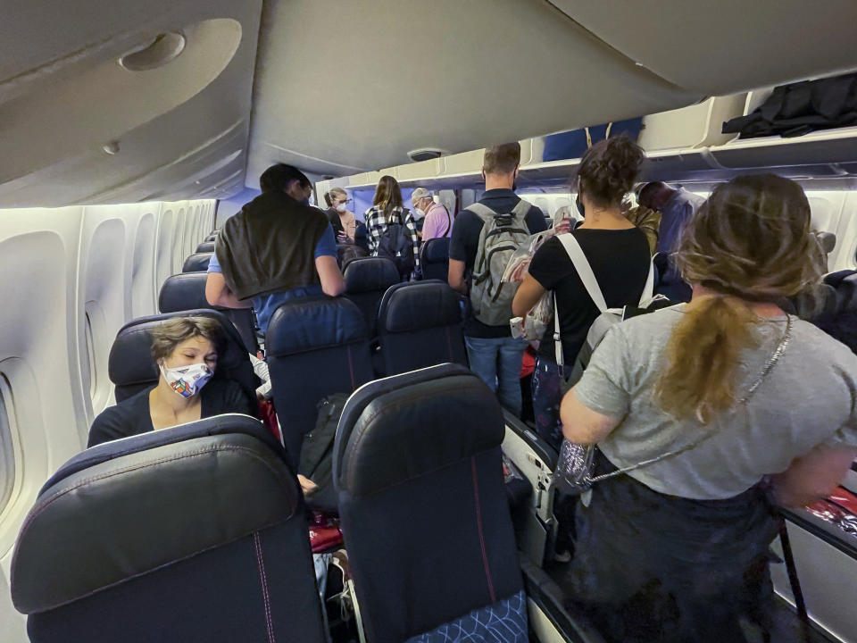 Passengers board an Air France flight bound for Paris at Johannesburg's OR Tambo airport Monday Dec. 21 2020. More and more countries around the world are restricting travel from Britain and elsewhere, including South Africa, amid concerns about new strains of the coronavirus. (AP Photo/Jerome Delay)