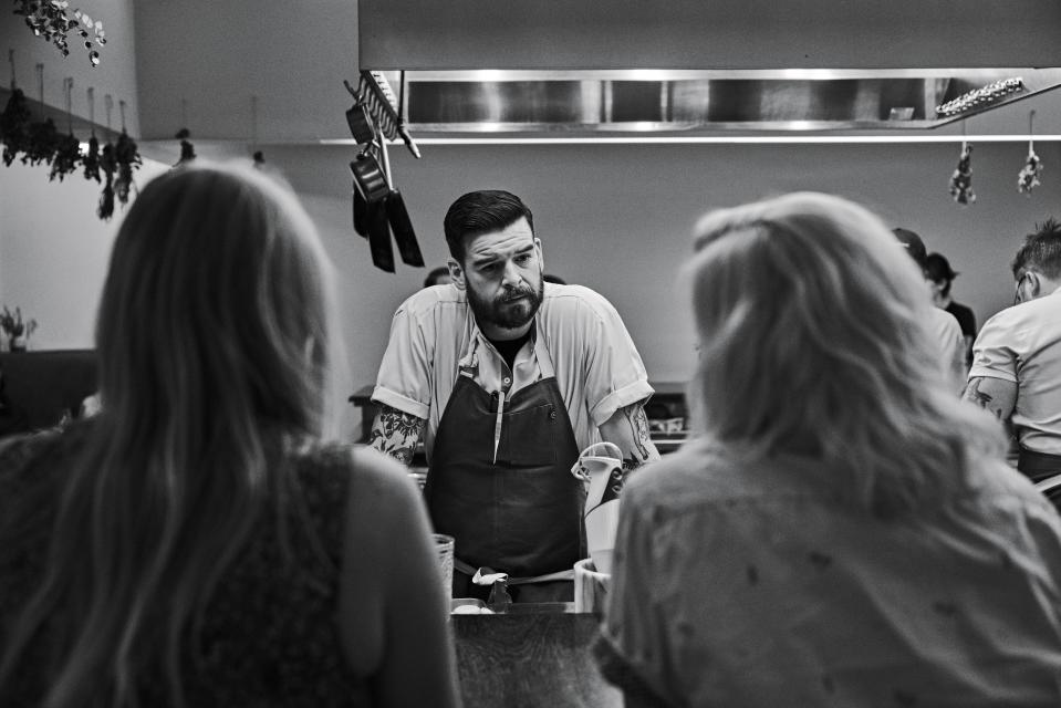 Chef Brian Baxter talks to customers during service at The Catbird Seat.