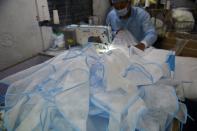 A worker stiches protective aprons at a production facility in the outskirts of Ahmedabad.