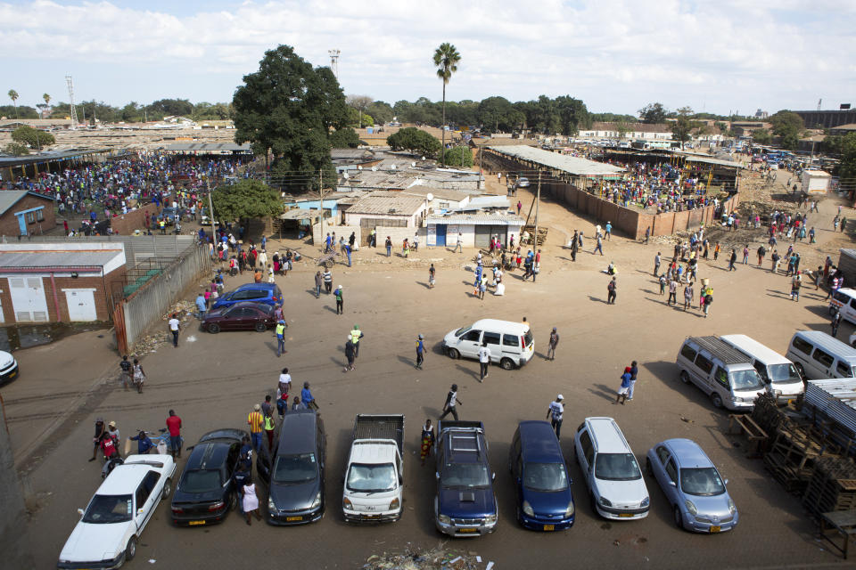 Hundreds of people buy goods at a fruit and vegetable market, despite a lockdown in an effort to curb the spread of the coronavirus, in Harare, Zimbabwe, Tuesday April 7, 2020. (AP Photo/Tsvangirayi Mukwazhi)