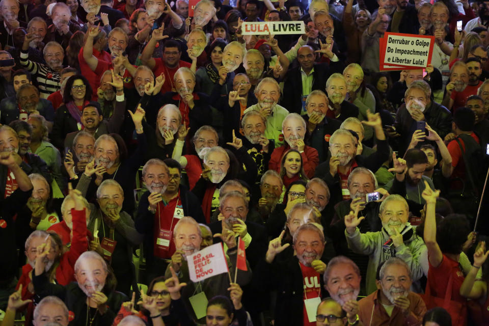 Supporters wears masks depicting Brazil's former President Luiz Inacio Lula da Silva during the Workers Party national convention in Sao Paulo, Brazil, Saturday, Aug. 4, 2018. The convention confirmed the jailed Lula da Silva as their candidate for the country's presidency in October's election. Da Silva leads the polls by a large margins, but is likely to be barred by Brazil's electoral justice. (AP Photo/Nelson Antoine)