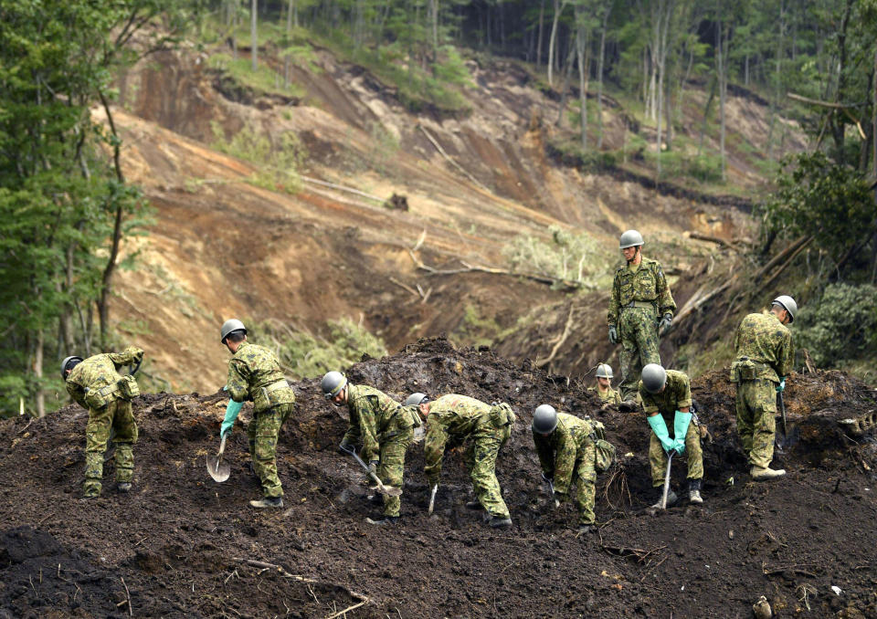 Japan's Self-Defense Force members work at the site of a landslide triggered by Thursday's earthquake in Atsuma, Hokkaido, northern Japan Sunday, Sept. 9, 2018. Japanese authorities say dozens of people have been confirmed dead from a powerful earthquake that struck the northern island of Hokkaido last week. (Yu Nakajima/Kyodo News via AP)