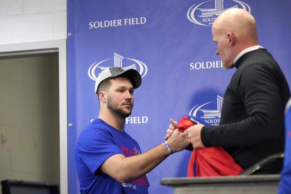 Buffalo Bills quarterback Josh Allen shakes hands with head coach Sean McDermott as Allen arrives and McDermott departs a news conference after an NFL football game against the Chicago Bears Saturday, Dec. 24, 2022, in Chicago. The Bills won 35-13. (AP Photo/Charles Rex Arbogast)