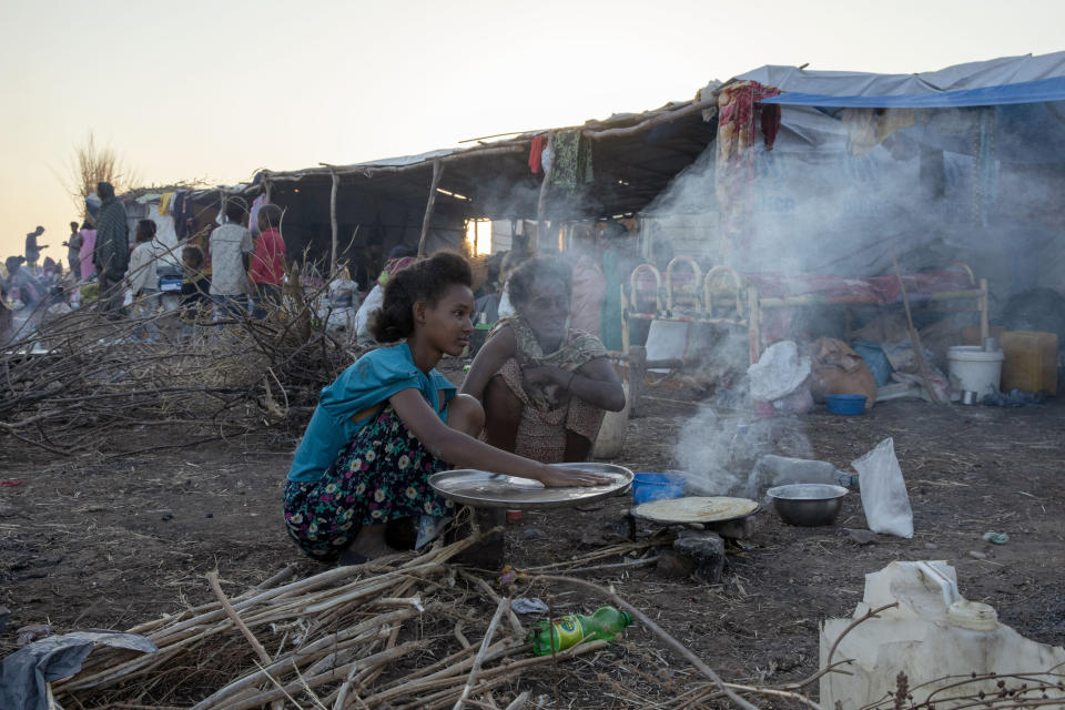 Tigray refugees who fled the conflict in the Ethiopia's Tigray cook breakfast at Hamdeyat Transition Center near the Sudan-Ethiopia border, eastern Sudan, Thursday, Dec. 3, 2020. Ethiopian forces on Thursday blocked people from the country's embattled Tigray region from crossing into Sudan at the busiest crossing point for refugees, Sudanese forces said.(AP Photo/Nariman El-Mofty)