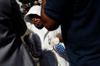 A boy dressed as a boxer stands as mourners gather outside Muhammad Ali's childhood home. REUTERS/Carlos Barria