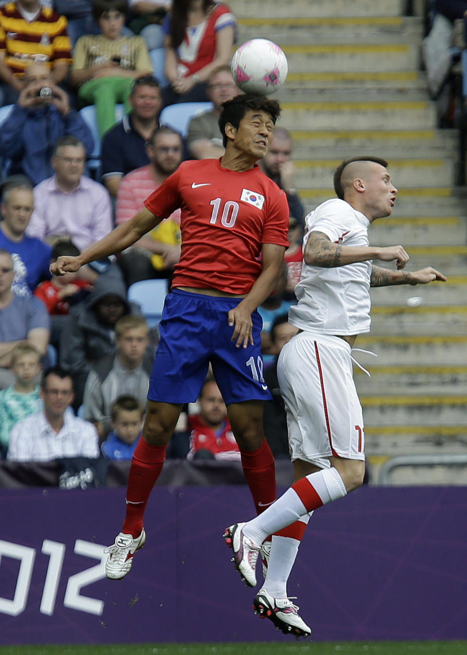 South Korea's Park Chu-young, left, battles for the ball against Switzerland's Michel Morganella during the group B men's soccer match between South Korea and Switzerland at the London 2012 Summer Olympics, in Coventry, England, Sunday, July 29, 2012. (AP Photo/Hussein Malla)