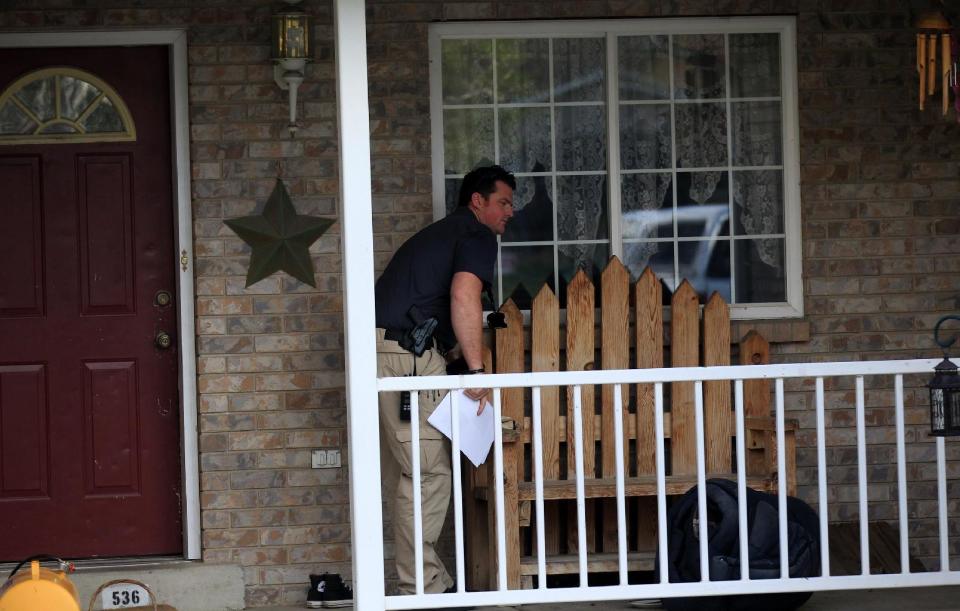 Pleasant Grove Police investigate the scene where seven infant bodies were discovered and packaged in separate containers at a home in Pleasant Grove, Utah, Sunday, April 13, 2014. According to the Pleasant Grove Police Department, seven dead infants were found in the former home of Megan Huntsman, 39. Huntsman was booked into jail on six counts of murder. (AP Photo/Rick Bowmer)