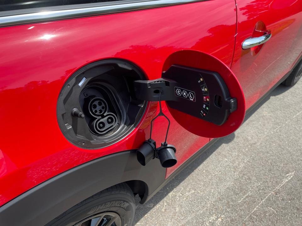 The gas cap on a 2023 red Mini Cooper SE.