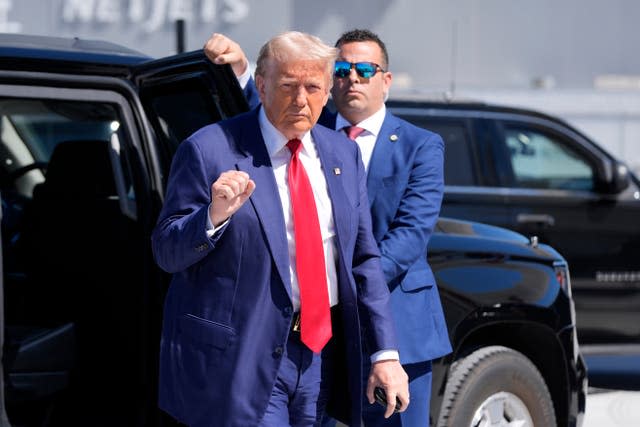 Republican presidential nominee former US president Donald Trump gestures as he arrives at an airport 