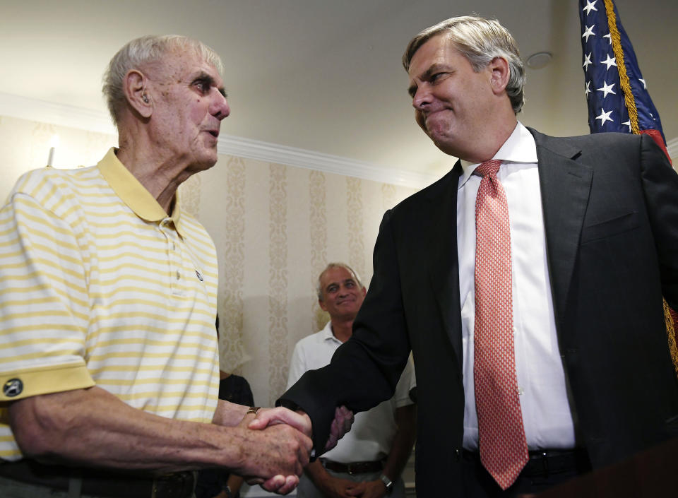 FILE - In this Aug. 14, 2018 file photo, Republican gubernatorial candidate Bob Stefanowski, right, shakes the hand of his father, Bob Stefanowski Sr., in Madison, Conn., after defeating four other contenders in the Connecticut primary. The candidate touts his work at blue-chip companies like General Electric and UBS Investment Bank. Rivals criticized the most recent item on his resume: CEO of DFC Global company, which offers financial products that are not legal in Connecticut. Stefanowski counters that his experience straightening out the troubled company would serve him well fixing the state's stubborn budget deficits. (AP Photo/Jessica Hill, File)