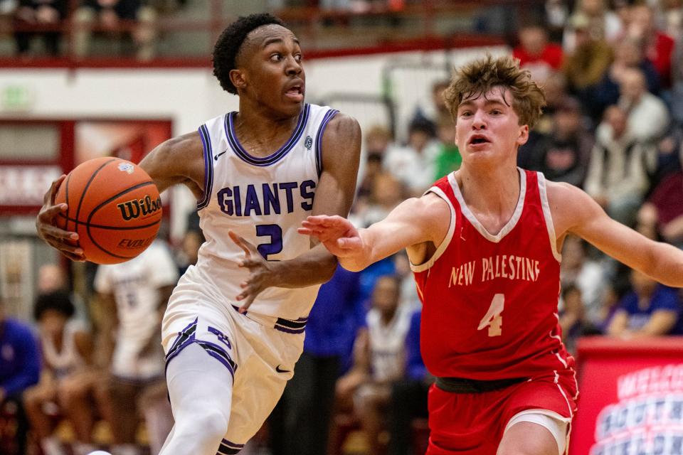 Ben Davis High School junior Mark Zackery IV (2) drives toward the basket while being defended by New Palestine High School junior Moses Haynes (4) during the first half of an IHSAA Class 4A Boys Regional basketball game, Saturday, March 9, 2024, at Southport High School.