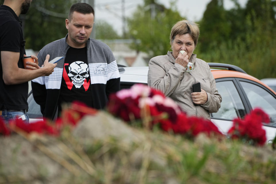 A woman reacts at an informal memorial next to the former 'PMC Wagner Centre' in St. Petersburg, Russia, Thursday, Aug. 24, 2023. Russian mercenary leader Yevgeny Prigozhin, the founder of the Wagner Group, reportedly died when a private jet he was said to be on crashed on Aug. 23, 2023, killing all 10 people on board. (AP Photo/Dmitri Lovetsky)