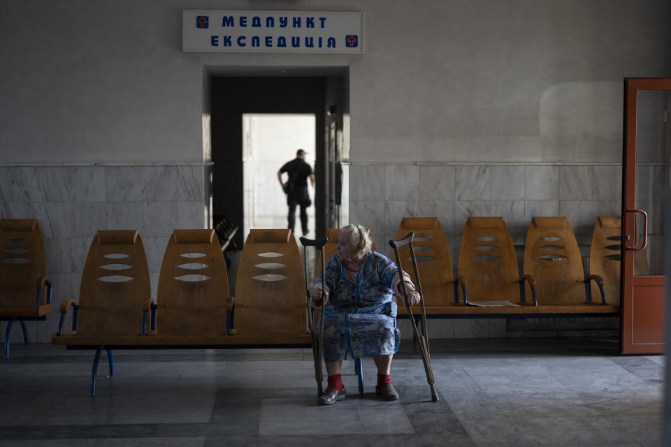 An elderly woman waits at a train station before boarding a train at a train station in Pokrovsk, Ukraine, Monday, April 25, 2022, to flee the war in Severodonetsk and nearby towns. Russia unleashed a string of attacks against Ukrainian rail and fuel installations Monday, striking crucial infrastructure far from the front line of its eastern offensive. (AP Photo/Leo Correa)