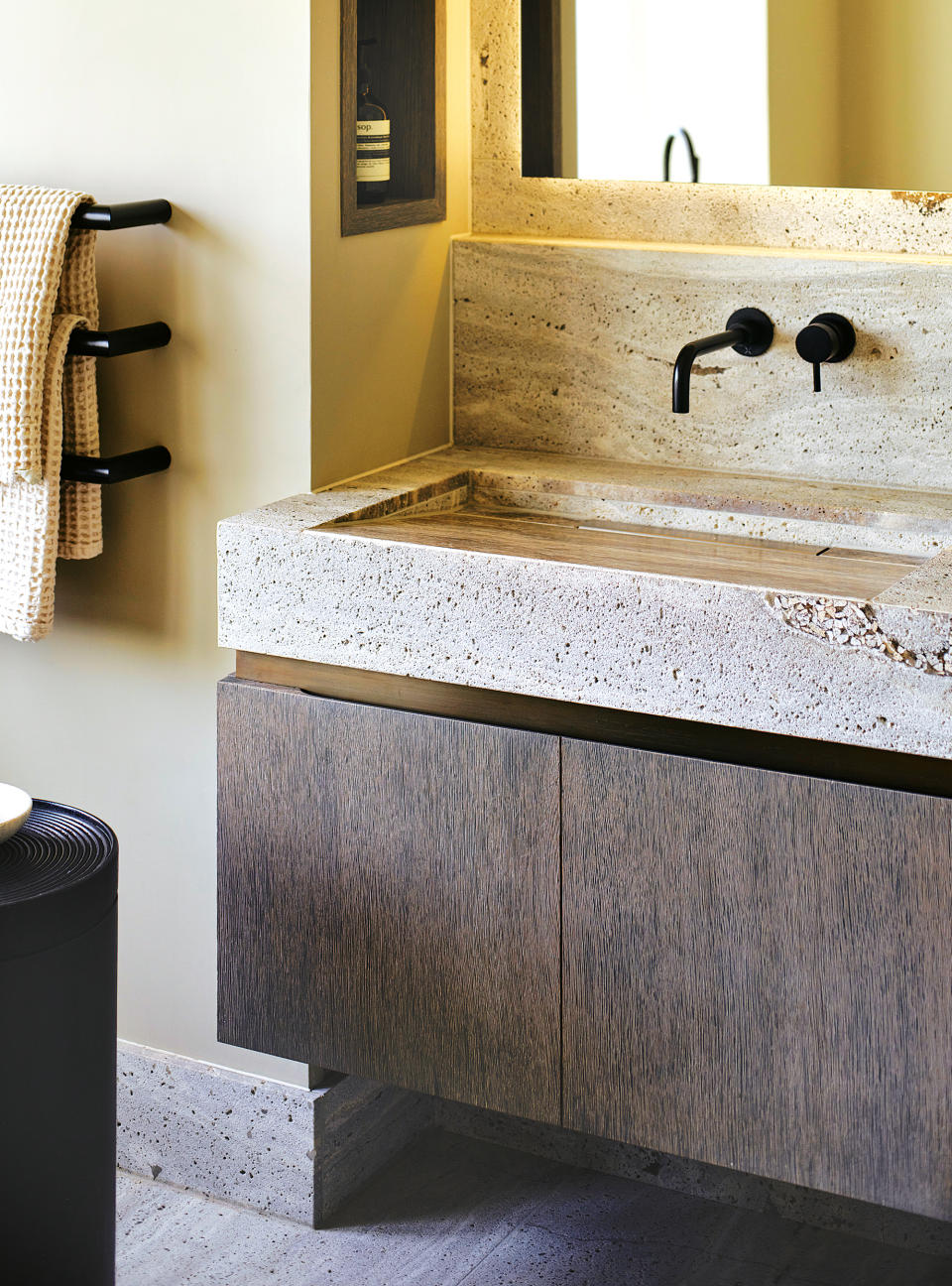 <p> Raw limestone and brushed oak make a compelling duo that champions nature’s imperfections. For this modern bespoke bathroom vanity unit by Hetherington Newman, interior designer Lisa Keates specified an unfilled Belgian limestone for the external elements of the vanity top, and the same material honed and filled for the basin interiors. </p> <p> ‘The idea was to enjoy the beautiful texture and practical durability without switching materials, while the brushed fumed oak cabinet featuring a bronze shadow gap adds yet more texture,’ explains Lisa, founder of Keates Interiors. ‘Stone needs resealing regularly to stop agents such as soap or toothpaste from etching the surface finish,’ she advises. </p>