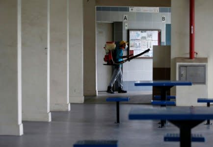 A worker sprays insecticide along the common areas of a public housing estate at an area where locally transmitted Zika cases were discovered in Singapore August 30, 2016. REUTERS/Edgar Su