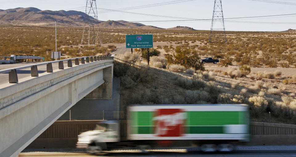 FILE - This photo taken Wednesday, Jan. 25, 2012, shows the site of a proposed station for a high-speed rail line to Las Vegas, background, at the end of the Dale Evans Parkway exit from Interstate 15, on the far outskirts of the Mojave Desert city of Victorville, Calif. Brightline West and U.S. transportation secretary and other officials projecting that millions of ticket-buyers will be boarding trains by 2028. (AP Photo/Reed Saxon)