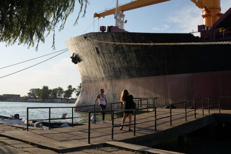Young people take a photo by a cargo ship heading to load grains in Reni, in Ukraine, on July 27, 2022 in Sulina, Romania. (Photo by Andreea Campeanu/Getty Images)