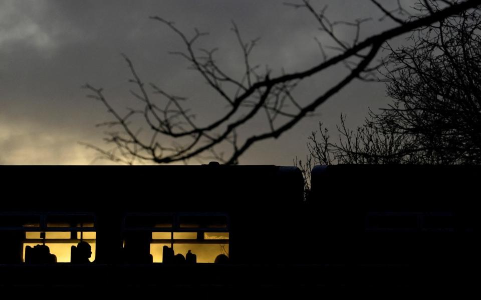 A passenger is silhouetted on a train crossing the river Thames