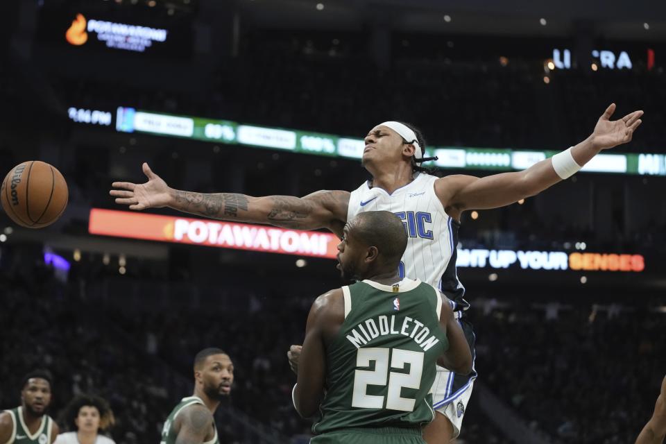 Milwaukee Bucks' Khris Middleton knocks the ball from Orlando Magic's Paolo Banchero during the first half of an NBA basketball game Thursday, Dec. 21, 2023, in Milwaukee. (AP Photo/Morry Gash)