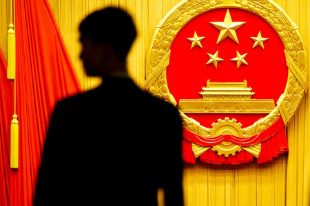 A member of the security personnel keeps watch at the end of the opening session of the National People's Congress (NPC) at the Great Hall of the People in Beijing, China March 5, 2018. REUTERS/Thomas Peter