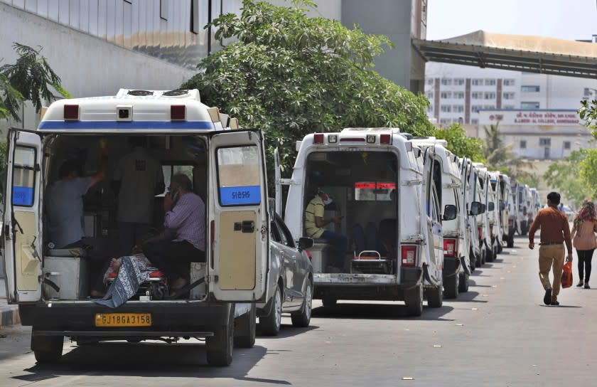 Ambulances carrying COVID-19 patients line up waiting for their turn to be attended to at a dedicated COVID-19 government hospital in Ahmedabad, India, Thursday, April 22, 2021. Indian authorities scrambled Saturday to get oxygen tanks to hospitals where COVID-19 patients were suffocating amid the world's worst coronavirus surge, as the government came under increasing criticism for what doctors said was its negligence in the face of a foreseeable public health disaster. (AP Photo/Ajit Solanki)