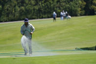 A greenskeeper sprays water onto the 12th green during practice for the Charles Schwab Challenge golf tournament at the Colonial Country Club in Fort Worth, Texas, Wednesday, June 10, 2020. (AP Photo/David J. Phillip)