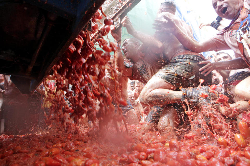 <p>A truck unloads tomatoes as crowds of people throw them at each other, during the annual “Tomatina”, tomato fight fiesta, in the village of Bunol, 50 kilometers outside Valencia, Spain, Aug. 31, 2016. (Photo: Alberto Saiz/AP)</p>