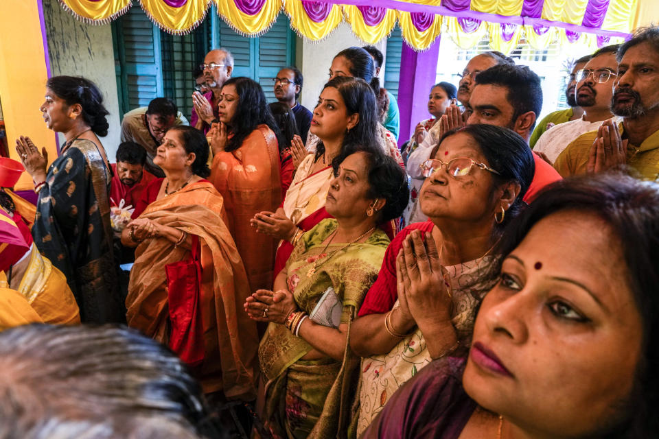 Devotees pray before an idol of Hindu goddess Durga on the second day of Durga Puja festival in Kolkata, India, Monday, Oct. 3, 2022. The five-day festival commemorates the slaying of a demon king by goddess Durga, marking the triumph of good over evil. (AP Photo/Bikas Das)