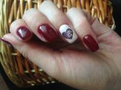 <p>The white feature nail, complete with a glittery heart, keeps this dark red design from feeling too serious.</p>