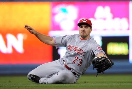 May 11, 2018; Los Angeles, CA, USA; Cincinnati Reds left fielder Adam Duvall (23) catches a hit off Los Angeles Dodgers first baseman Max Muncy (13) for the final out of the game at Dodger Stadium. Mandatory Credit: Gary A. Vasquez-USA TODAY Sports