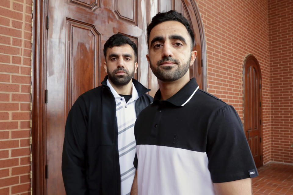 Brothers Samiullah Safi, left, and Abdul Wasi Safi pose for a picture after Friday prayers outside the Al-Noor Society Mosque in Houston, on April 7, 2023. Abdul, who had suffered injuries while assisting the U.S. military in Afghanistan during the war, has recently arrived in Houston after being detained for months, but has no documentation allowing him to begin a normal life with his brother. (AP Photo/Michael Wyke)