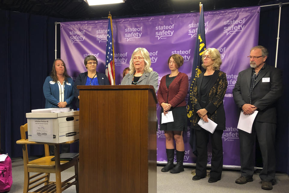 Carol Manstrom, whose 18-year-old son killed himself with a pistol that was left unlocked, speaks at a press conference on Wednesday, Sept. 18, 2019, in Salem, Ore. Manstrom on Wednesday helped deliver 2,000 signatures to Oregon's elections office to get a measure on the 2020 ballot that would create the most comprehensive law in America requiring the safe storage of weapons. Manstrom believes her son would be alive today if such a law had been enacted earlier and followed. Next to Manstrom is a box containing the signatures of 2,000 voters supporting the ballot measure. (AP Photo/Andrew Selsky)