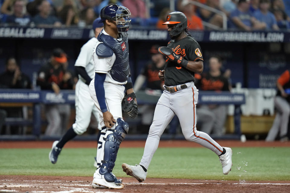 Baltimore Orioles' Jorge Mateo, right, scores in front of Tampa Bay Rays catcher Christian Bethancourt on a sacrifice fly by Adley Rutschman during the fifth inning of a baseball game Friday, Aug. 12, 2022, in St. Petersburg, Fla. (AP Photo/Chris O'Meara)