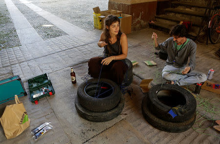 Members of the "Assemblea Cavallerizza 14:45" movement make seats using tires at the Cavallerizza Reale building, which is occupied by the movement in Turin, Italy, July 15, 2016.REUTERS/Marco Bello
