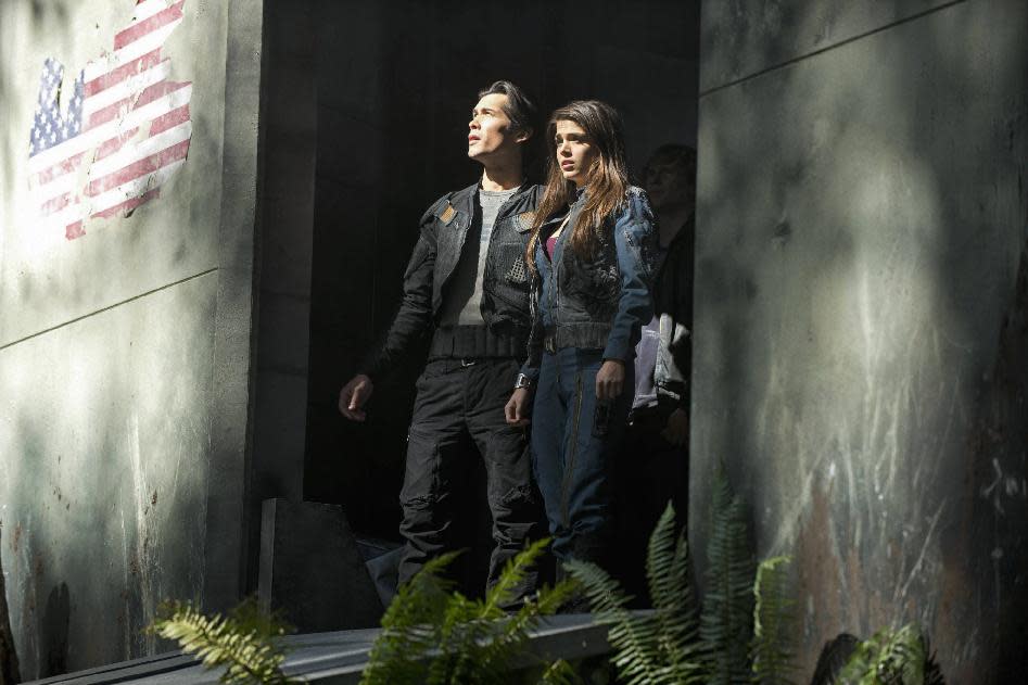 This publicity image released by The CW shows Bob Morley as Bellamy, left, and Marie Avgeropoulos as Octavia in the pilot episode of the new series "The 100," premiering this fall on The CW. (AP Photo/ The CW, Cate Cameron)