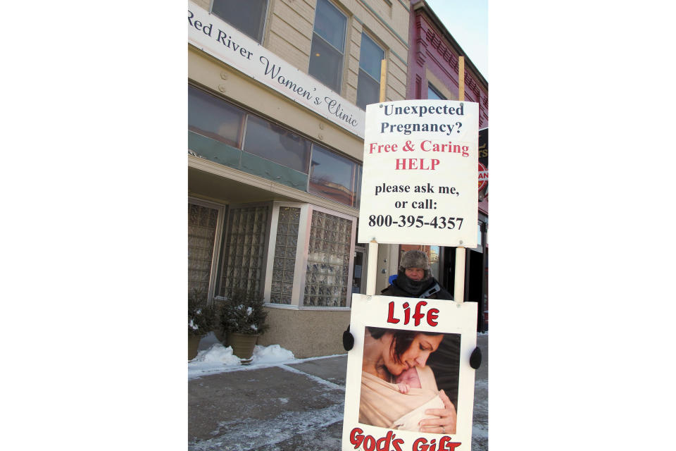 FILE - An abortion protester stands outside the Red River Valley Women's Clinic in Fargo, N.D., on Feb. 20, 2013. North Dakota's only abortion clinic is preparing for what could be its final day of performing procedures, with a trigger ban due to take effect Thursday, July 28, 2022, that will likely force patients to travel hundreds of miles to receive care pending the clinic's relocation across the border to Minnesota. (AP Photo/Dave Kolpack, File)