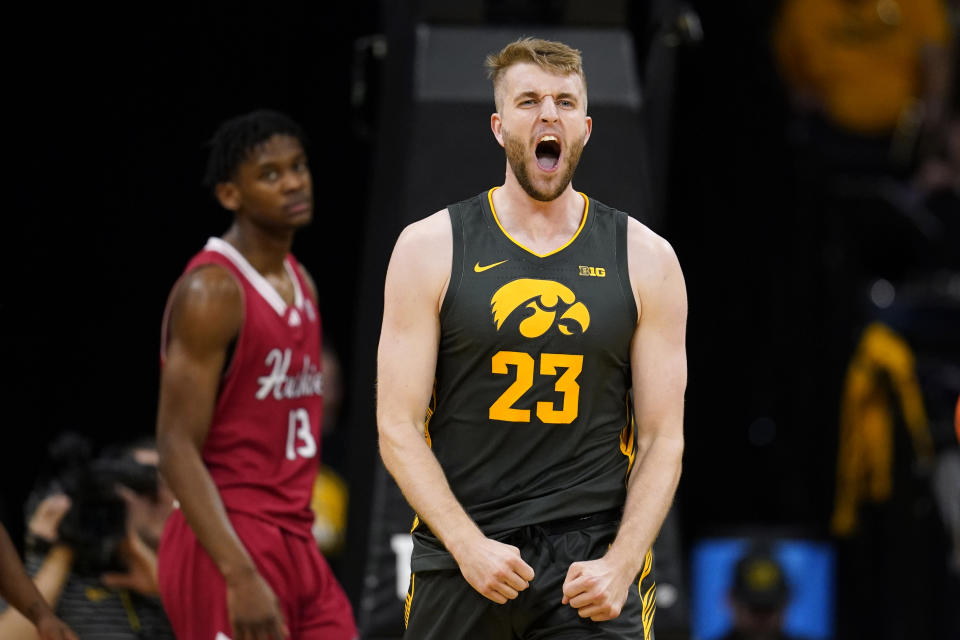 Iowa forward Ben Krikke (23) celebrates in front of Northern Illinois forward Xavier Amos (13) after making a basket during the first half of an NCAA college basketball game, Friday, Dec. 29, 2023, in Iowa City, Iowa. (AP Photo/Charlie Neibergall)
