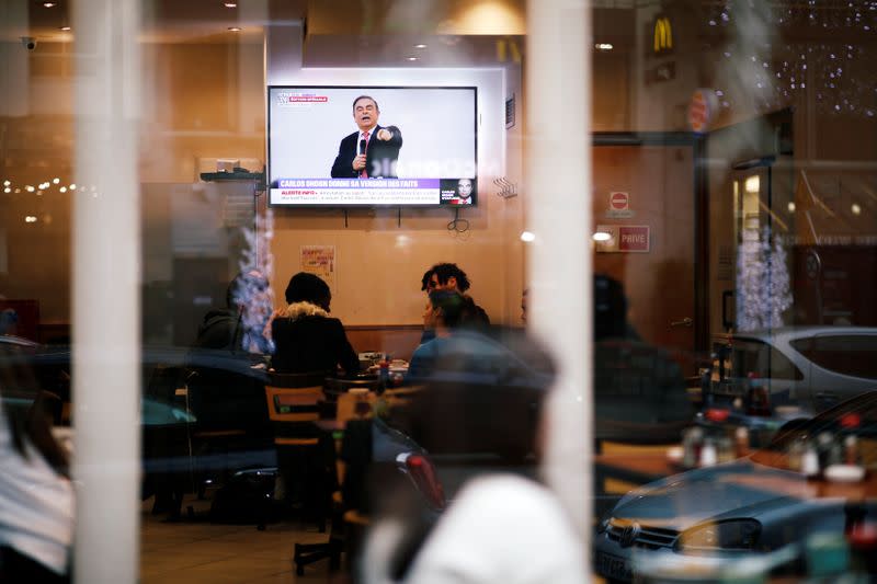 Customers at a Japanese restaurant watch on TV the live news conference of former Nissan chairman Carlos Ghosn in Paris