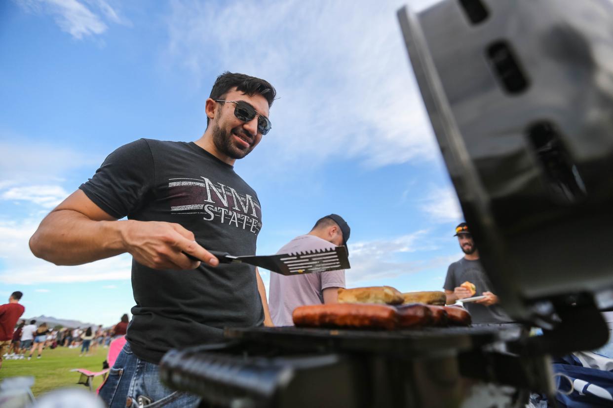 Greg Gonzales grills burgers and hotdogs before the NMSU-UTEP game at NMSU in Las Cruces on Saturday, Aug. 28, 2021.