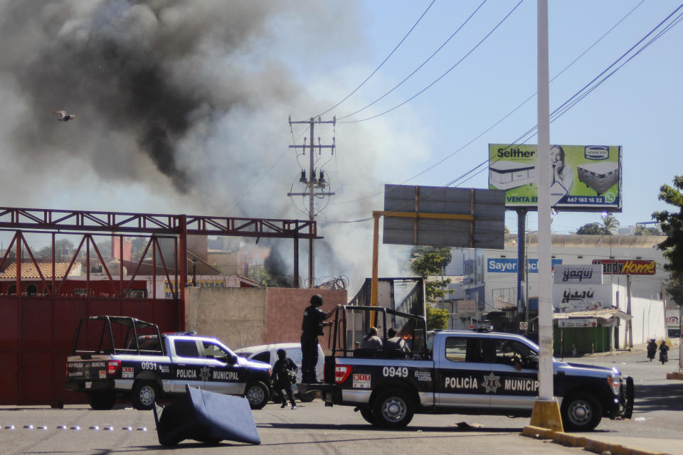 La policía llega al lugar en el que un local fue saqueado el jueves 5 de enero de 2023, en Culiacán, en el estado de Sinaloa, México. Las fuerzas de seguridad mexicanas capturaron a Ovidio Guzmán, un presunto narcotraficante buscado por Estados Unidos, el jueves en una operación antes del amanecer que desencadenó tiroteos y bloqueos de carreteras en la ciudad de Culiacán. (AP Foto/Martín Urista)