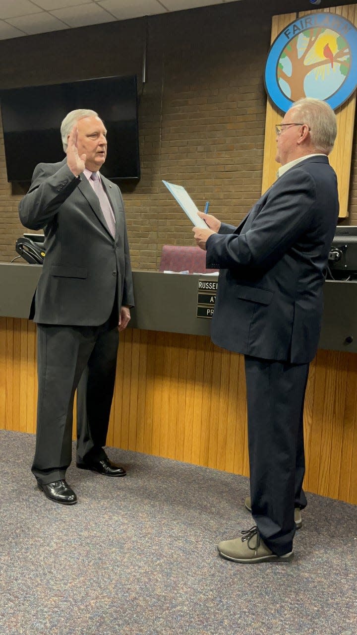 Russell Sharnsky, left, the longtime Fairlawn City Council president, is ceremonially sworn in as mayor Monday by outgoing Mayor William Roth.