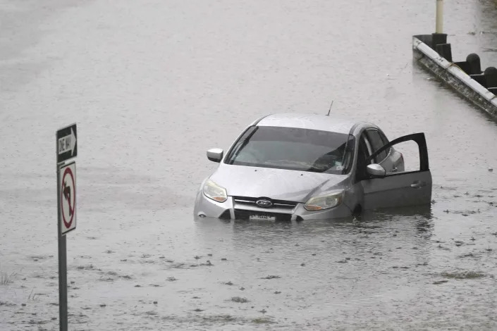 An abandoned car sits in floodwaters on a highway in Dallas on Monday. (AP Photo/LM Otero)