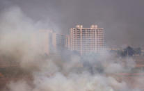 Residential buildings are visible behind the stubble burning smoke at a rice field in Zirakpur in Punjab, October 10, 2018. REUTERS/Adnan Abidi